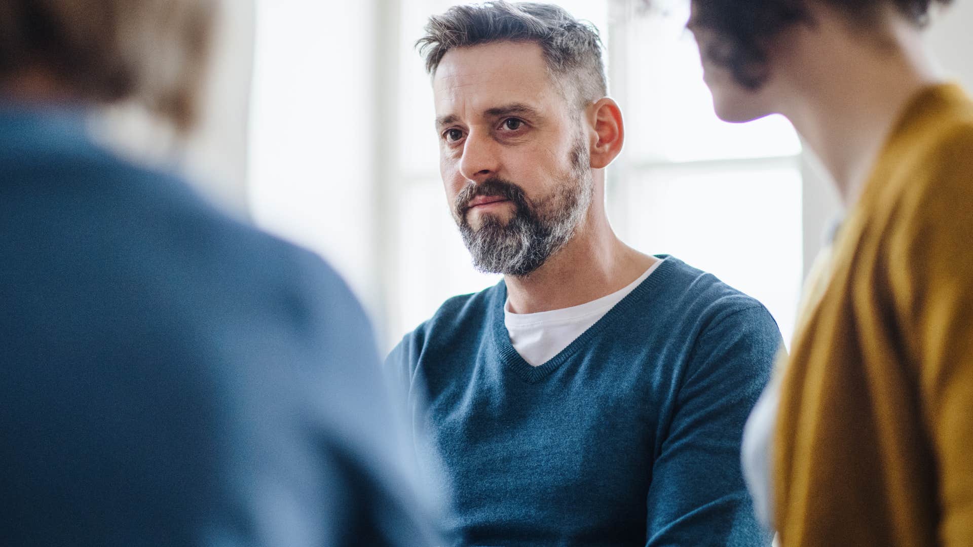 Upset man looking at other people setting boundaries.
