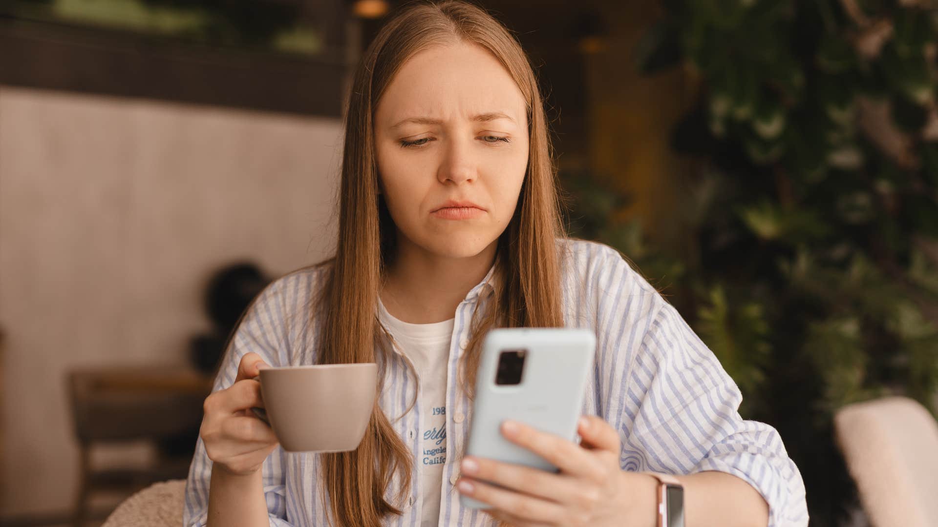 Woman upset about seeing other people happy on her phone.
