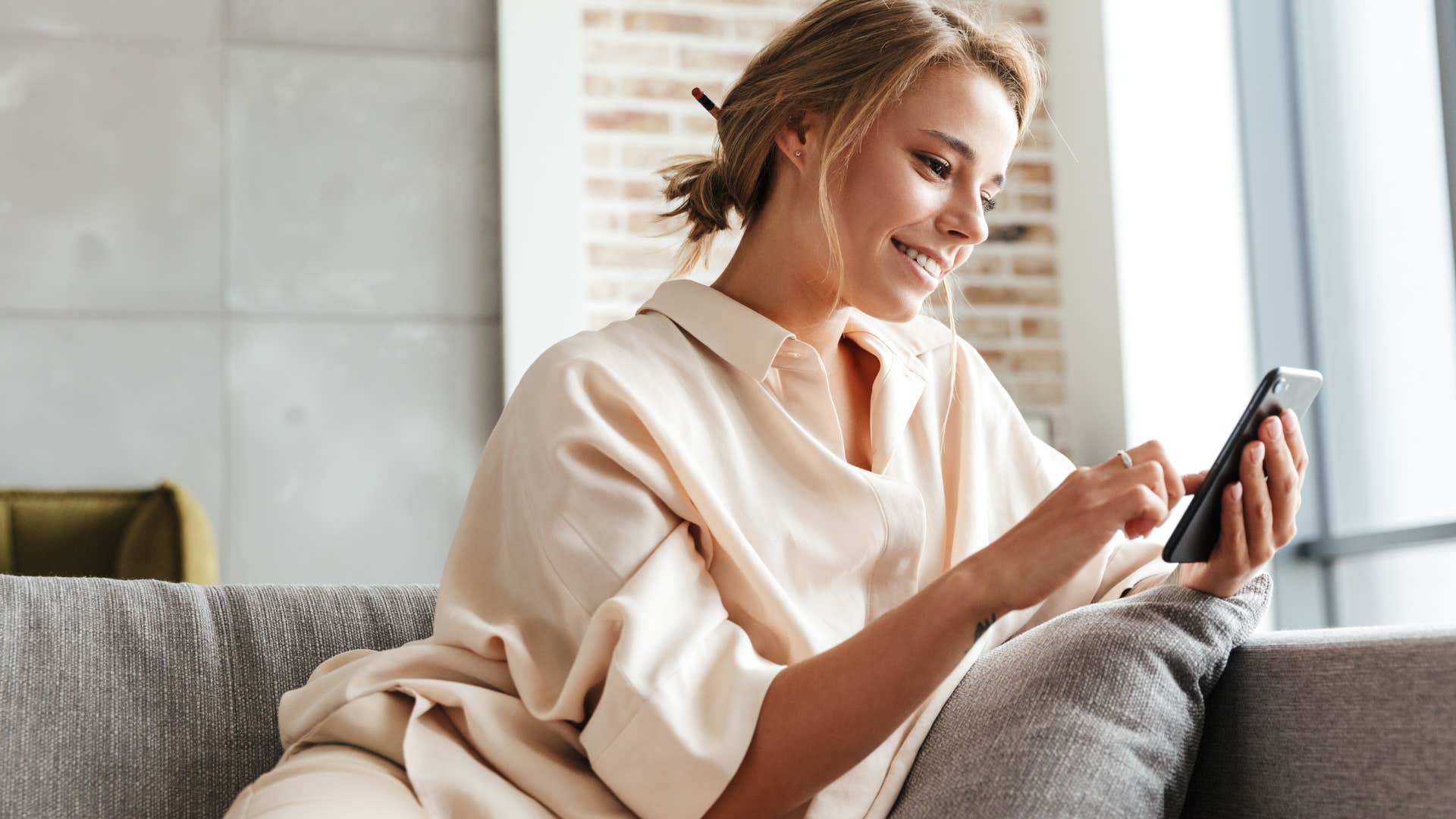 Woman with bare walls sitting at home.