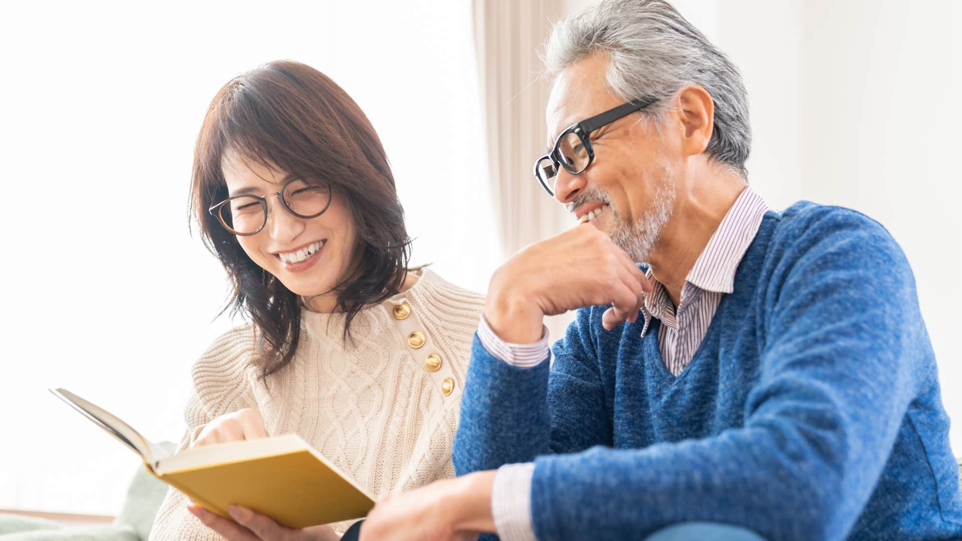 Couple who doesn't have a TV reading at home.