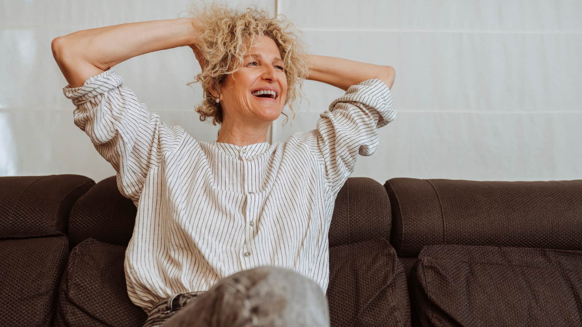 Woman living in a small home and smiling.
