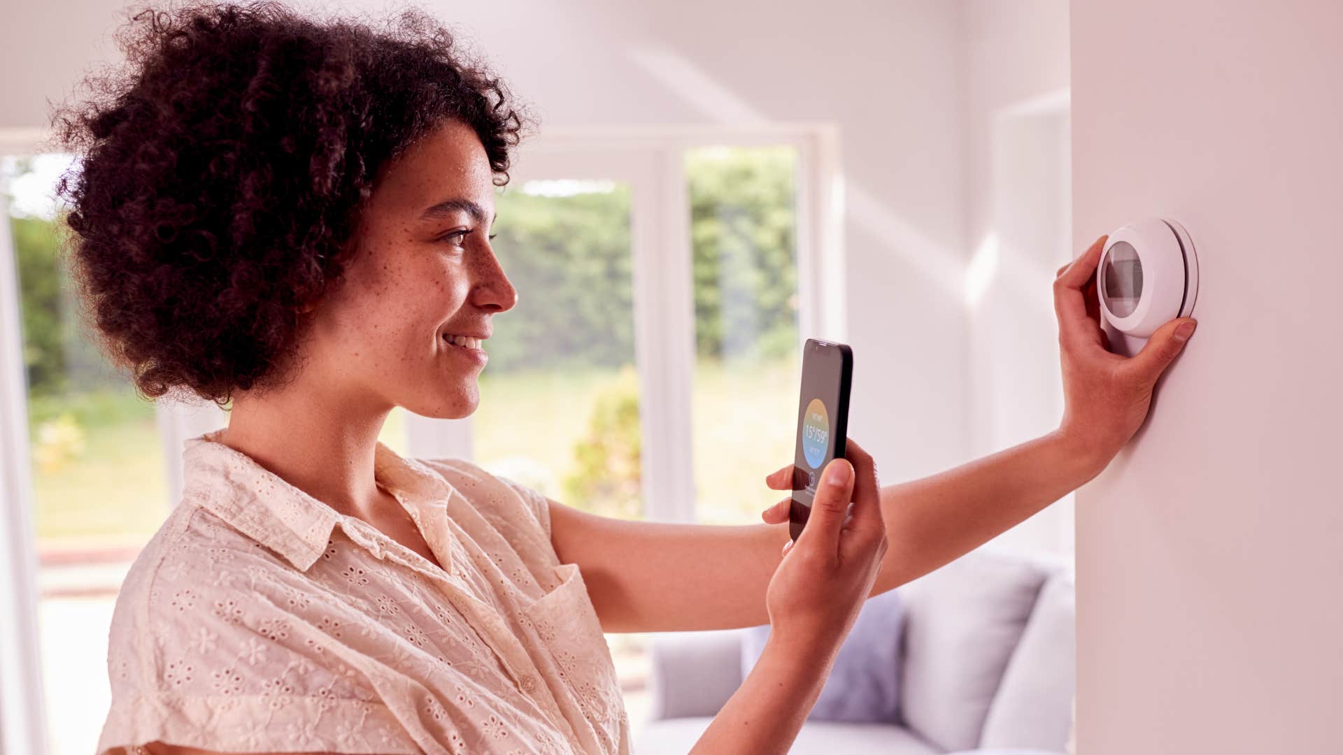 woman using smart home devices with her thermostat