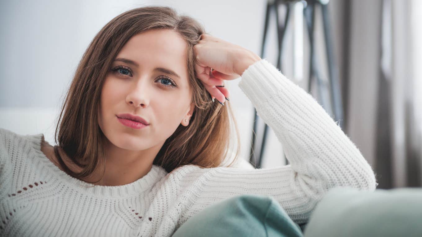 introverted intelligent woman sitting at home on the couch