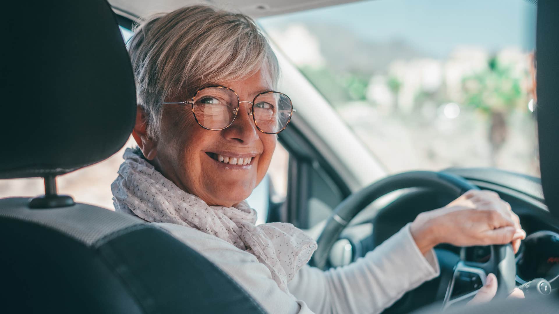 woman who's always willing to help smiling in her car