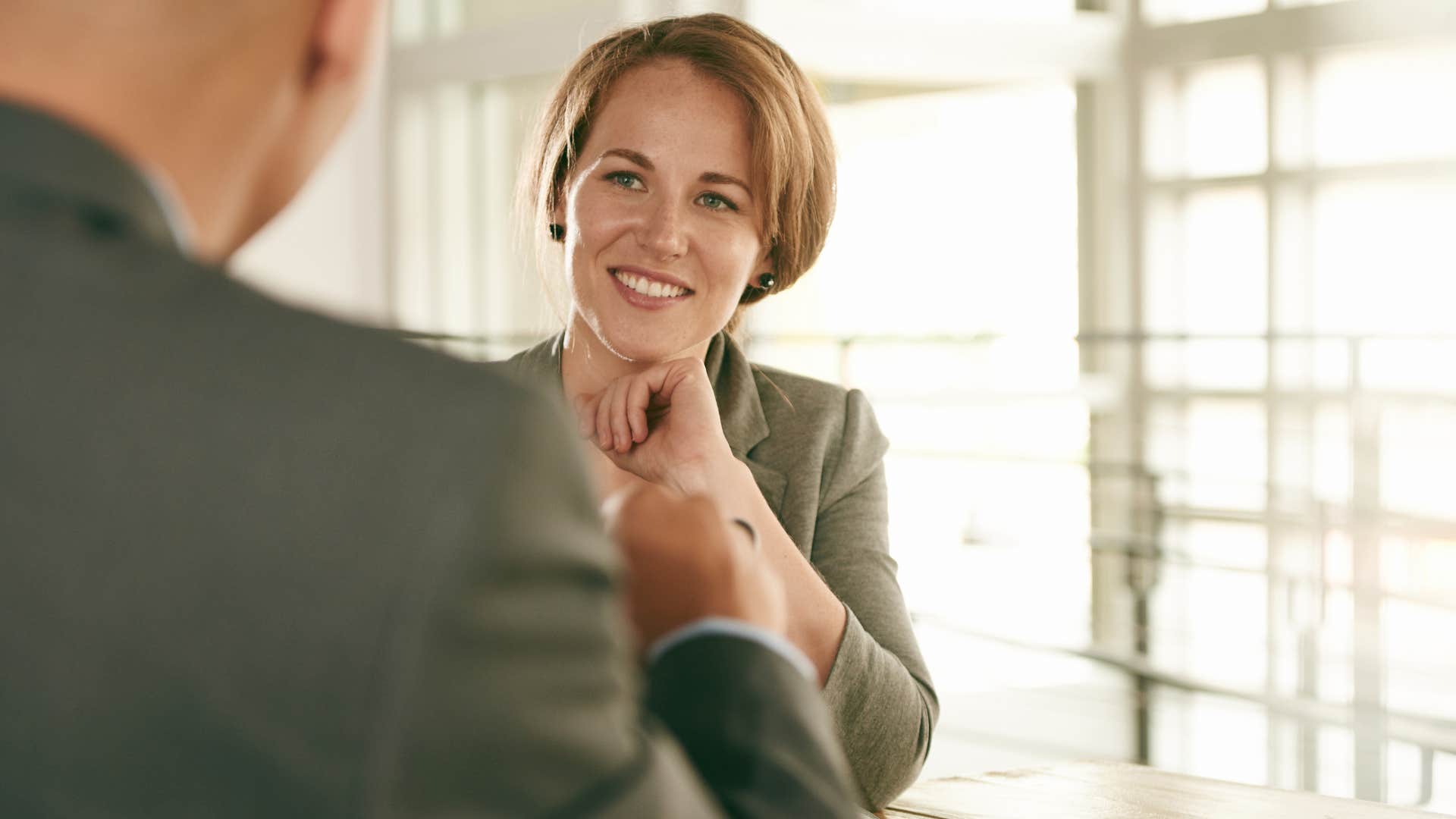 woman who's incredibly self-aware smiling at work