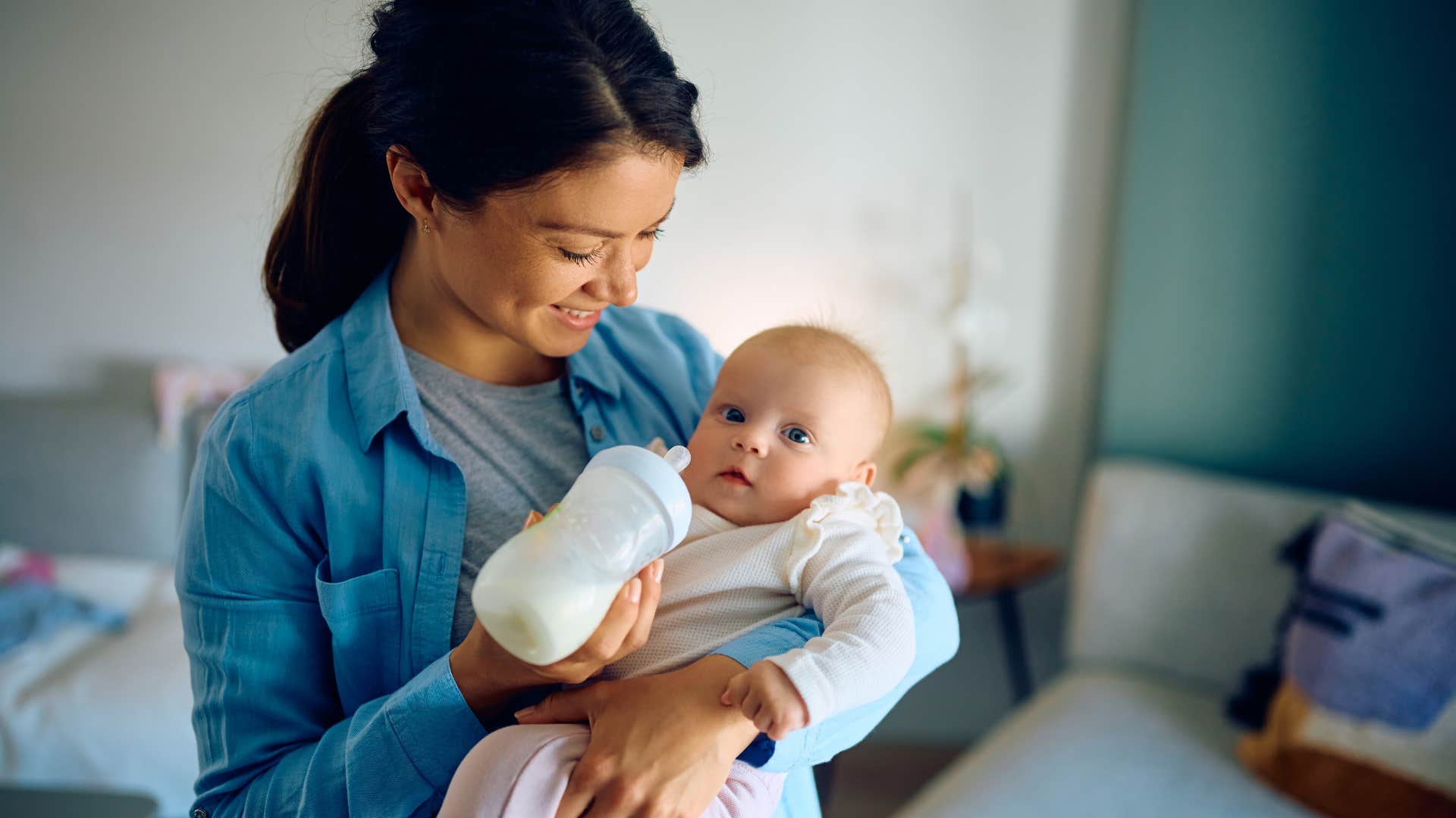 traits of a silky mom who has the whole parenting thing figured out bottle-feeds baby woman who is a silky mom as she bottle-feeds her baby