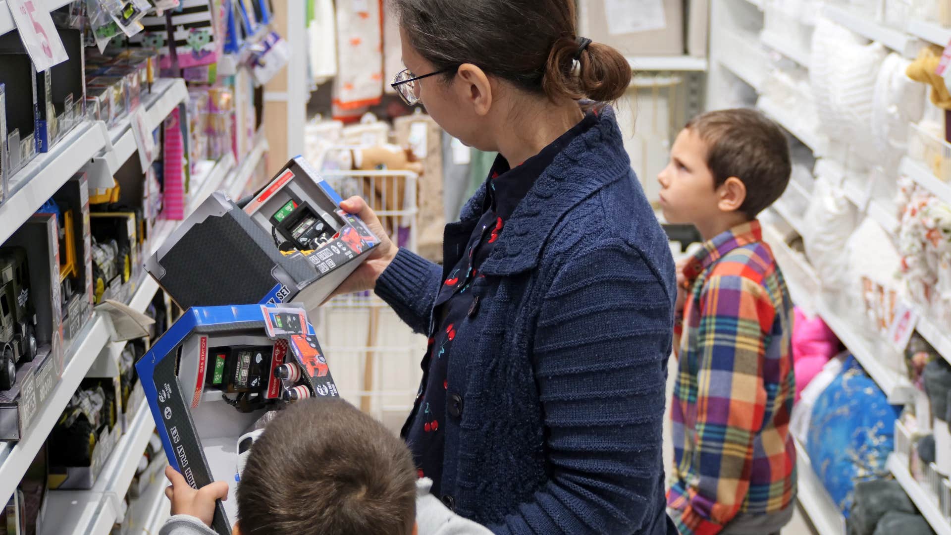 traits of a silky mom who has the whole parenting thing figured out buys plastic toys woman who is a silky mom who has the whole parenting thing figured out as she buys plastic toys