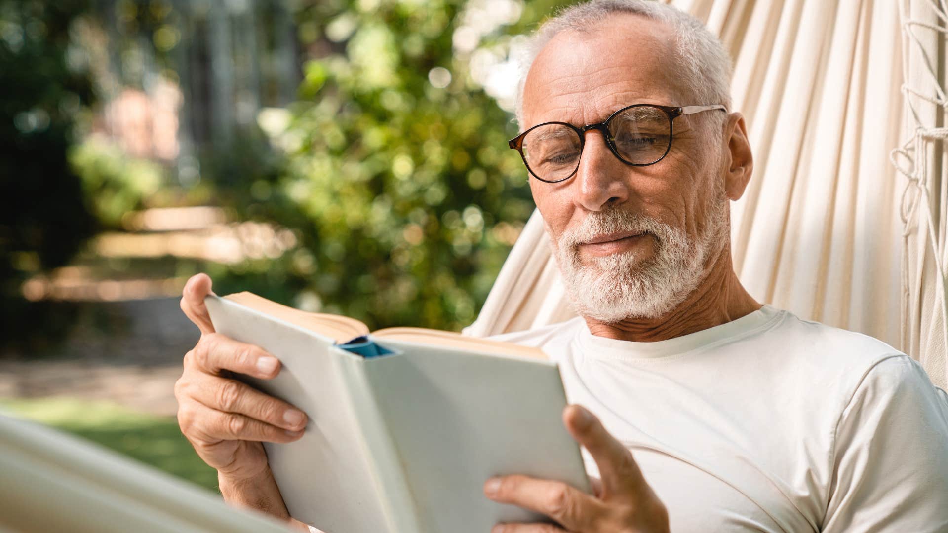 Man who appreciates silence reading a book outside.