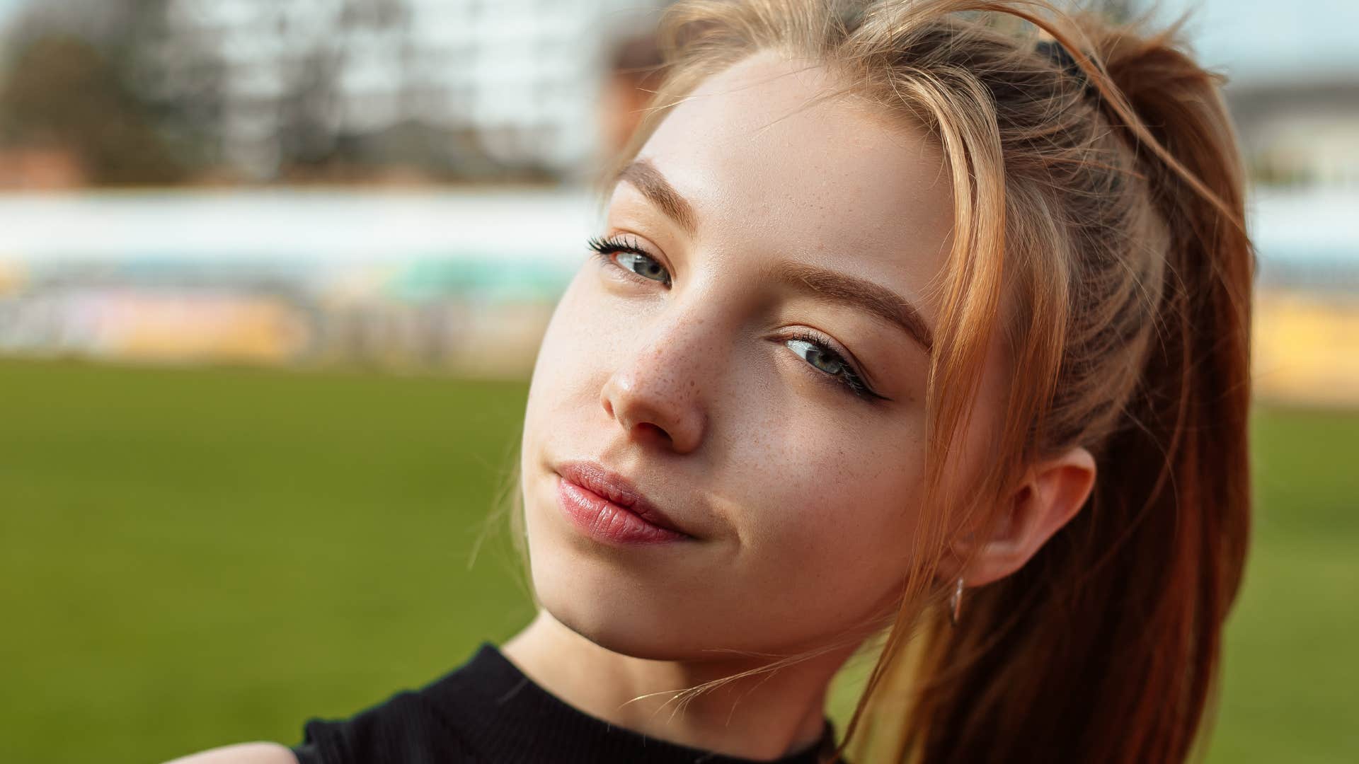Energetically aligned woman smiling outside.