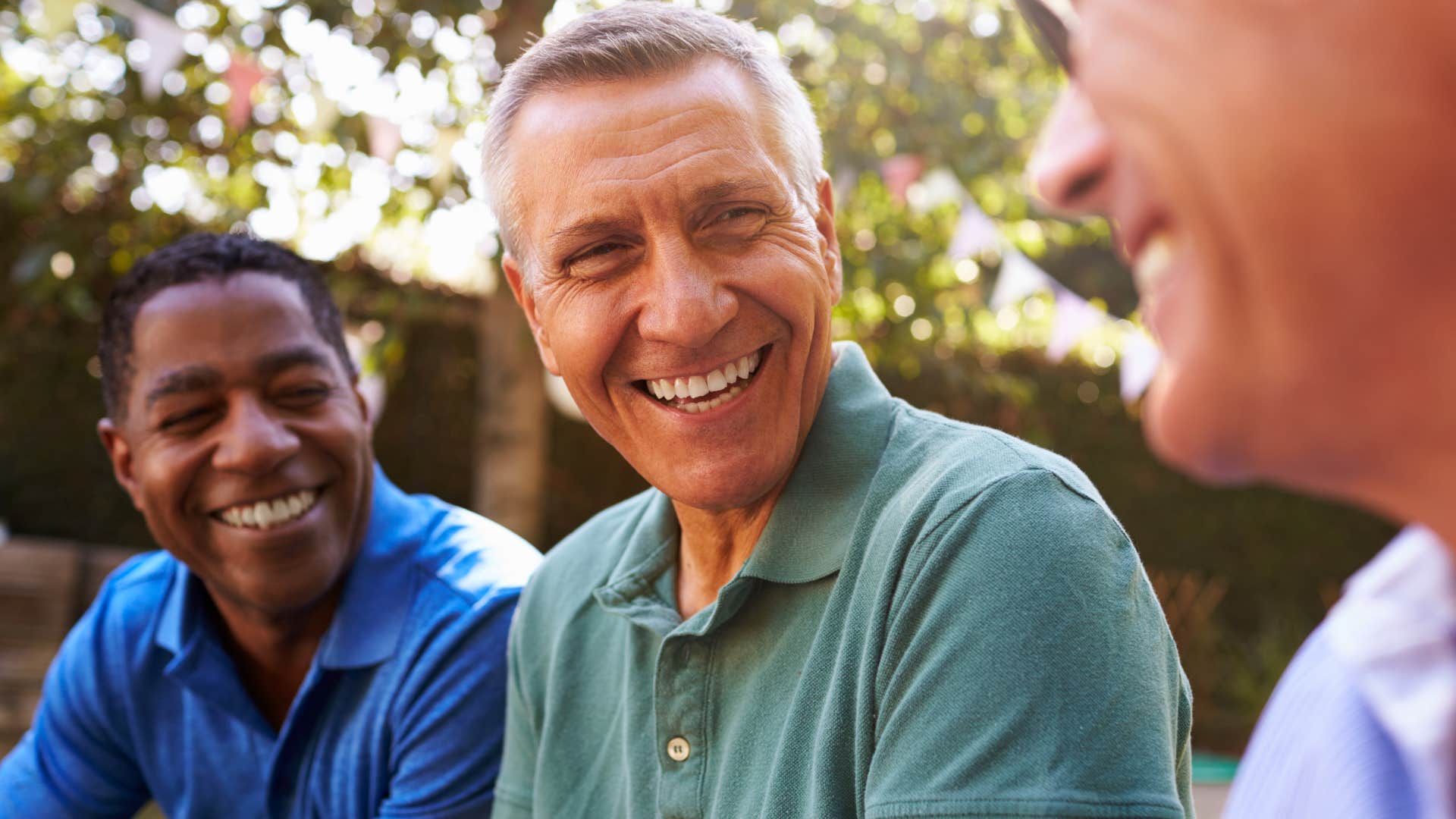Man who's quick to celebrate others smiling with friends.
