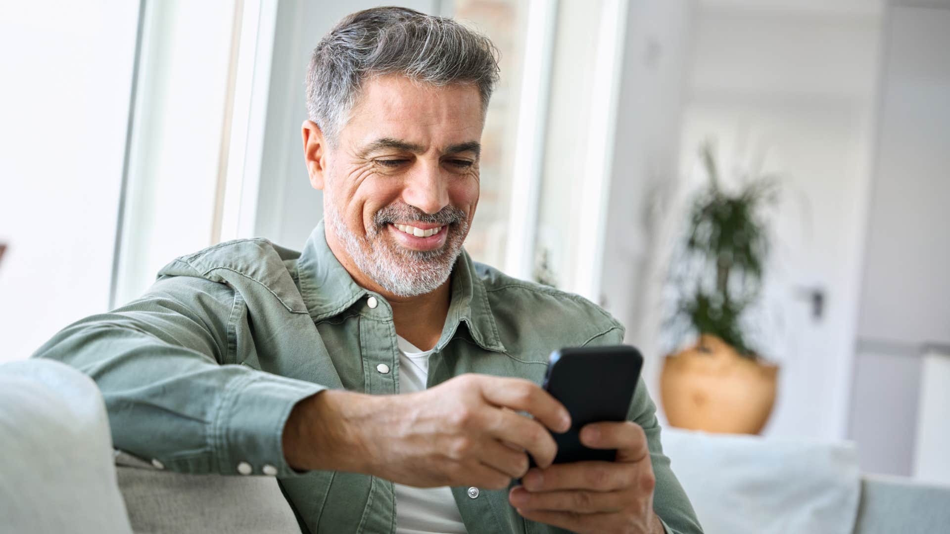 happy gen x man not seeking validation online looking at phone