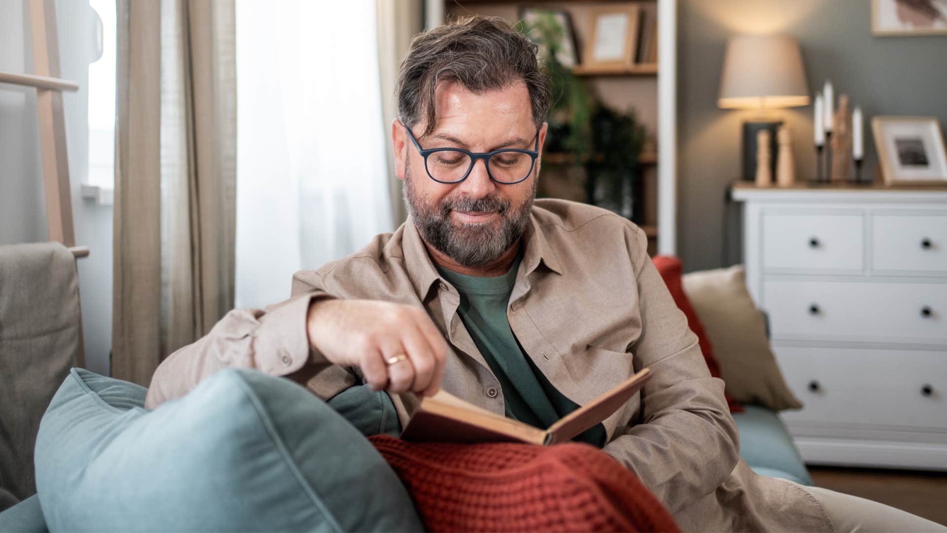 Man reading with books and journals scattered around.