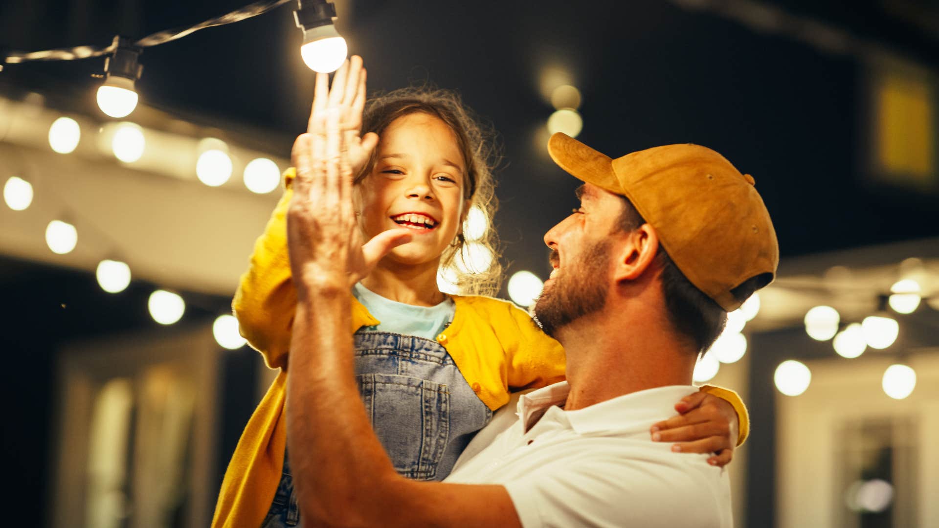 Man who's intentional about lighting holding his daughter.