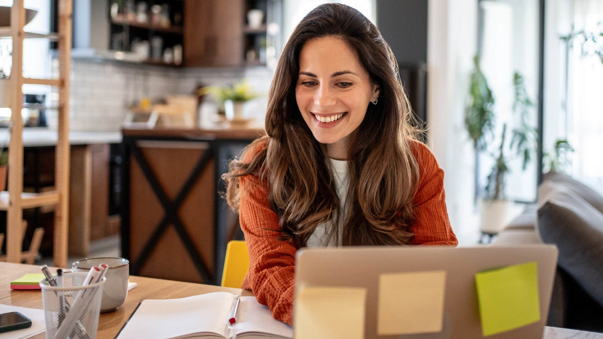 Woman using sticky notes for reminders at home.