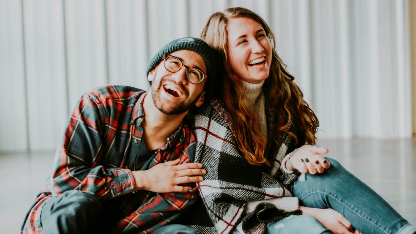 Playful couple laughing together, illustrating ways the most romantic couples keep their marriage full of sparks