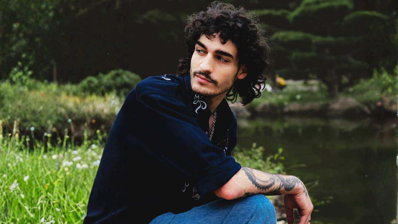 Man sitting contemplatively by a calm lake, illustrating the need for a personal space to process tears and emotions over the years