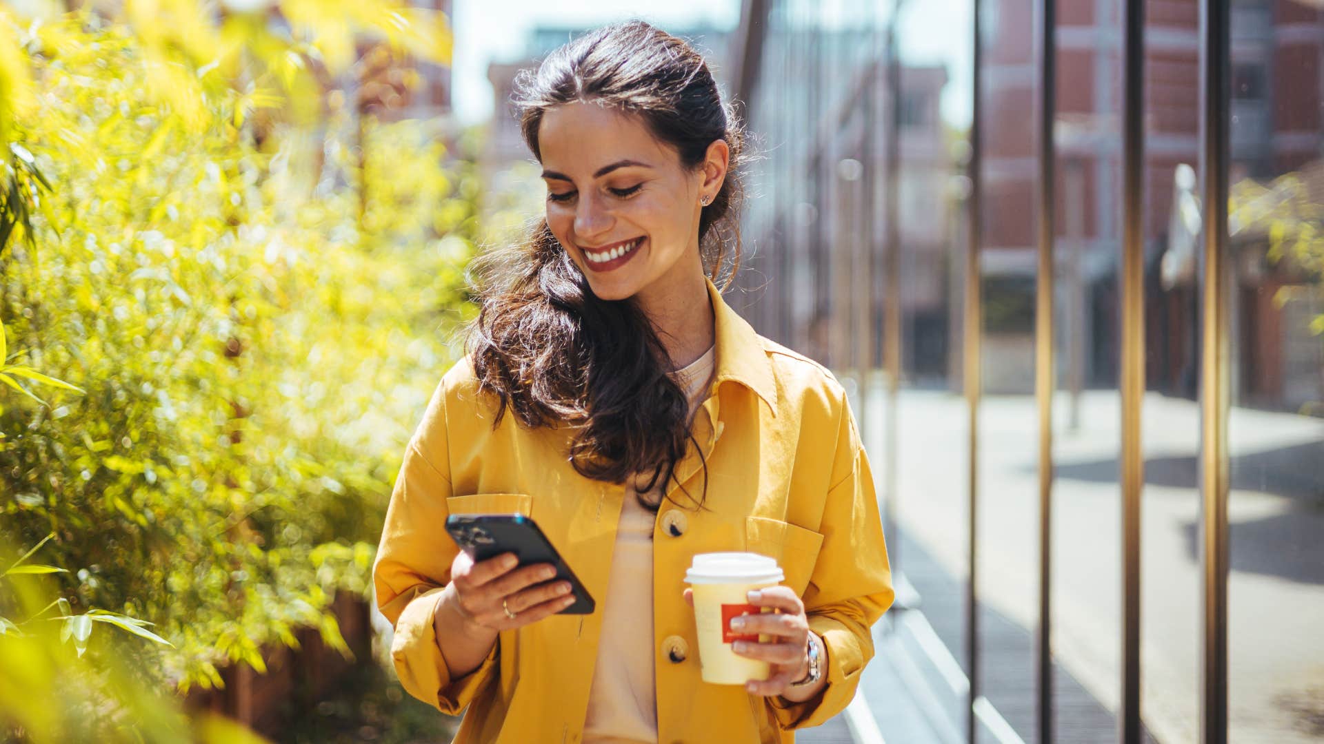 woman texting smiling and walking