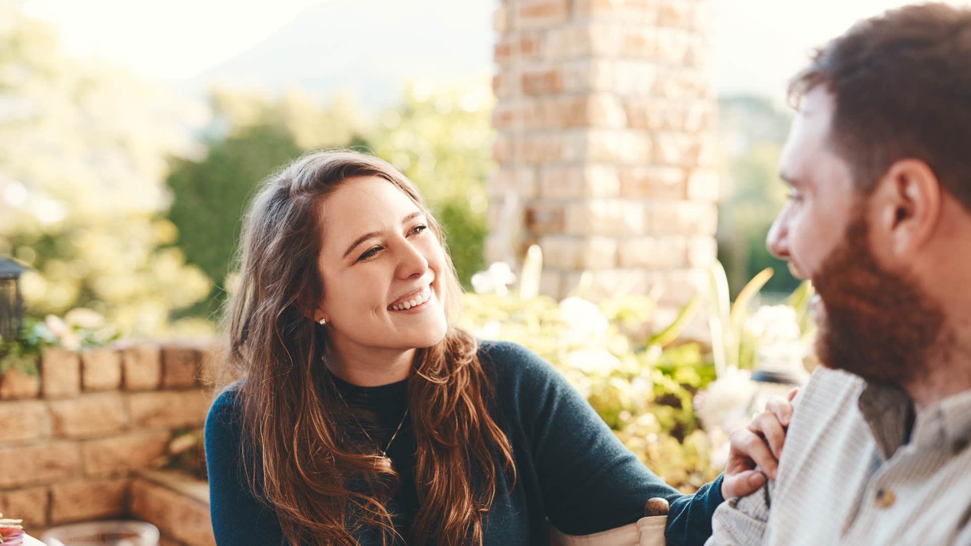 woman in green sweater smiling at man as she says we should do that together some time