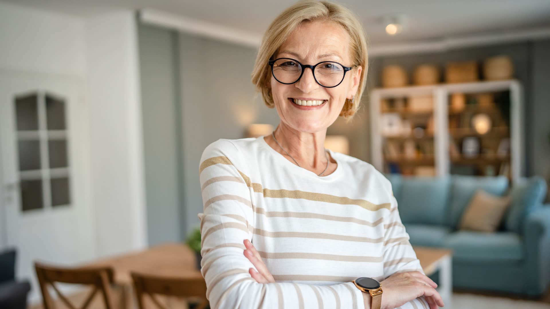 Woman who doesn't believe in traditional social norms smiling at home.