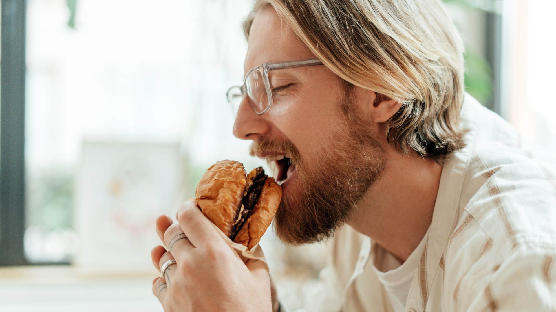 man who appreciates balance with food eating burger