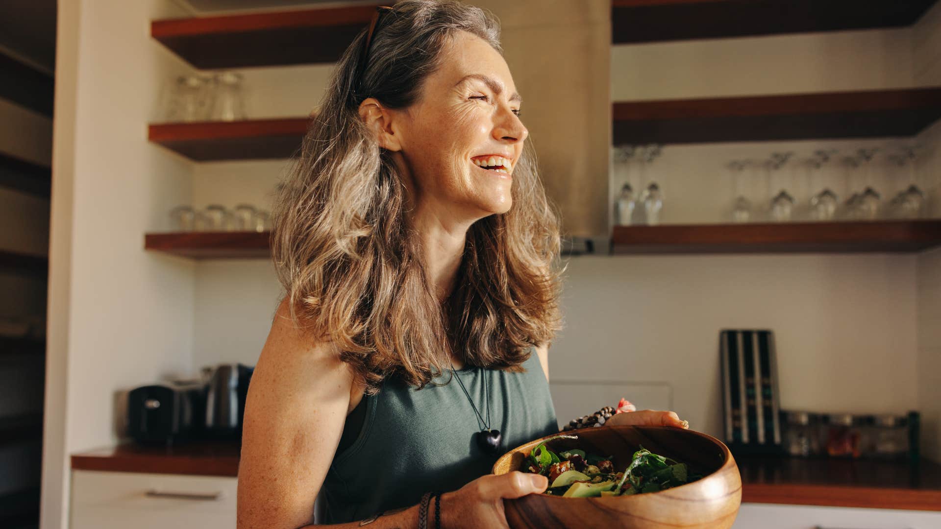 woman who respects other people's choices smiling with a salad at home