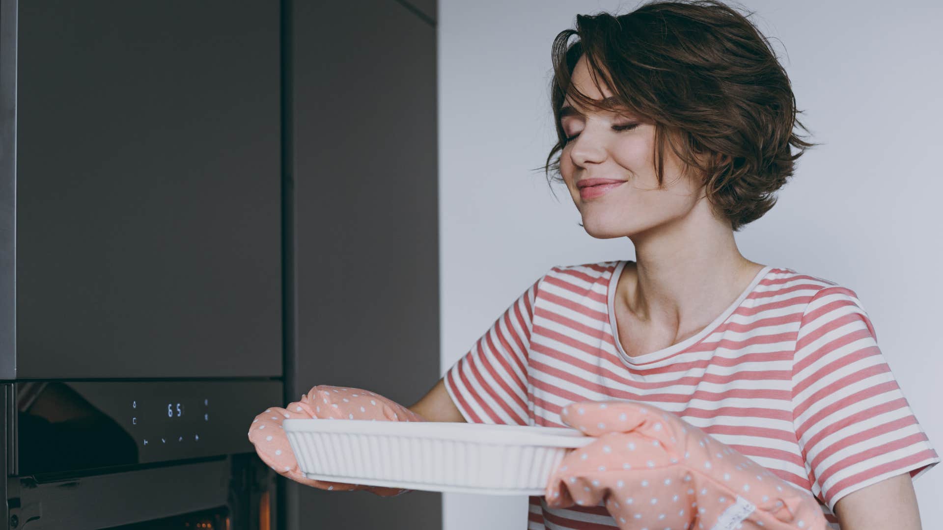 woman using all of their senses smelling a pan of food