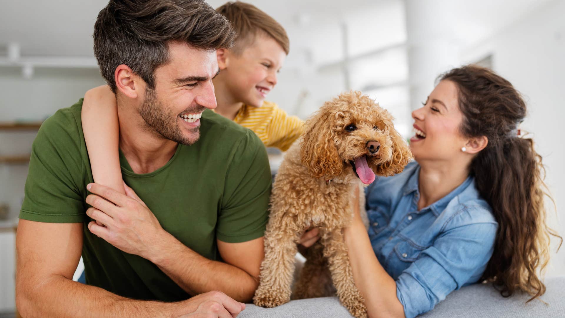 happy family smiling snuggling with new dog