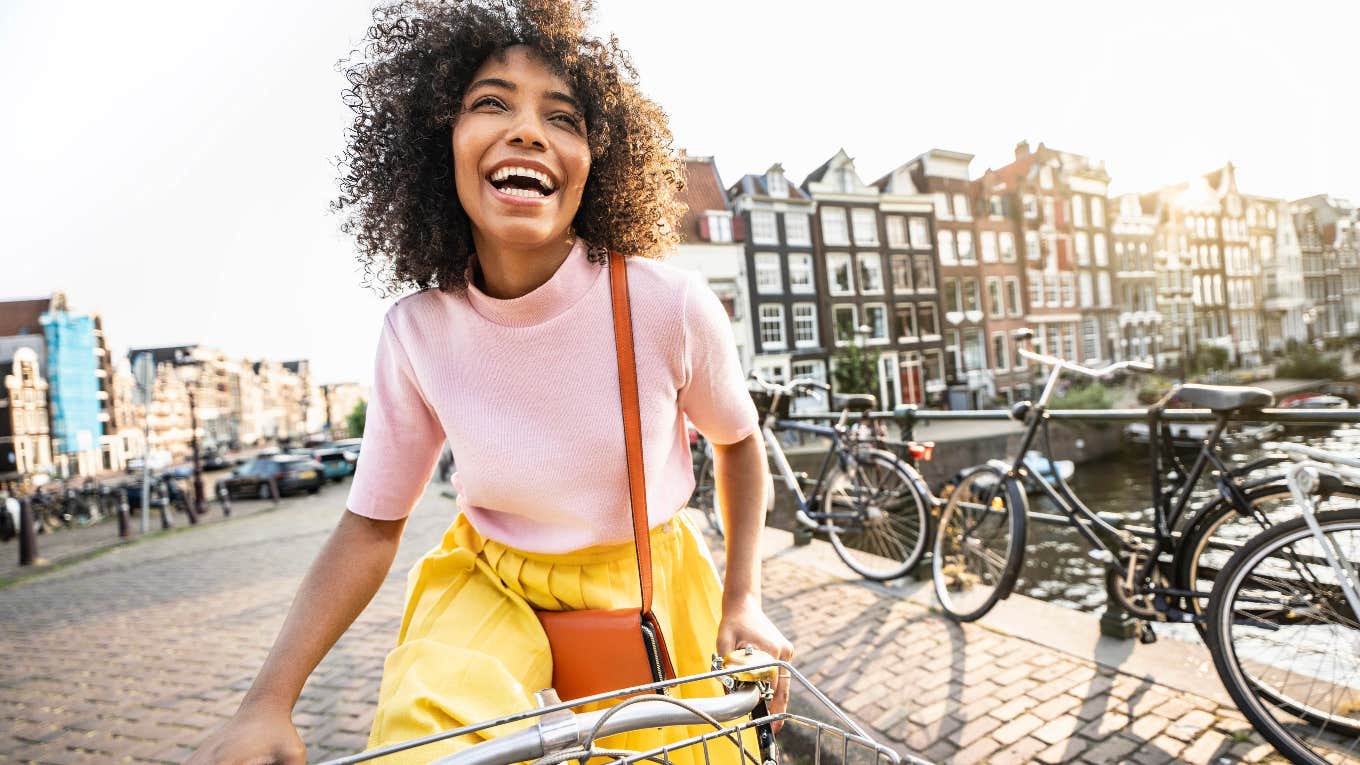 happy woman riding a bike on the streets of Europe