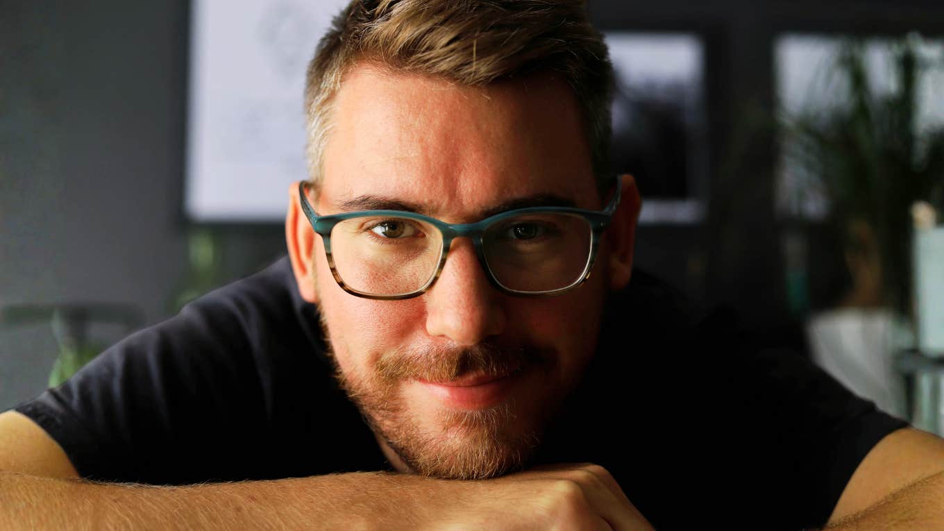 Warm confident man smiling indoors showing the art of being a decent husband.