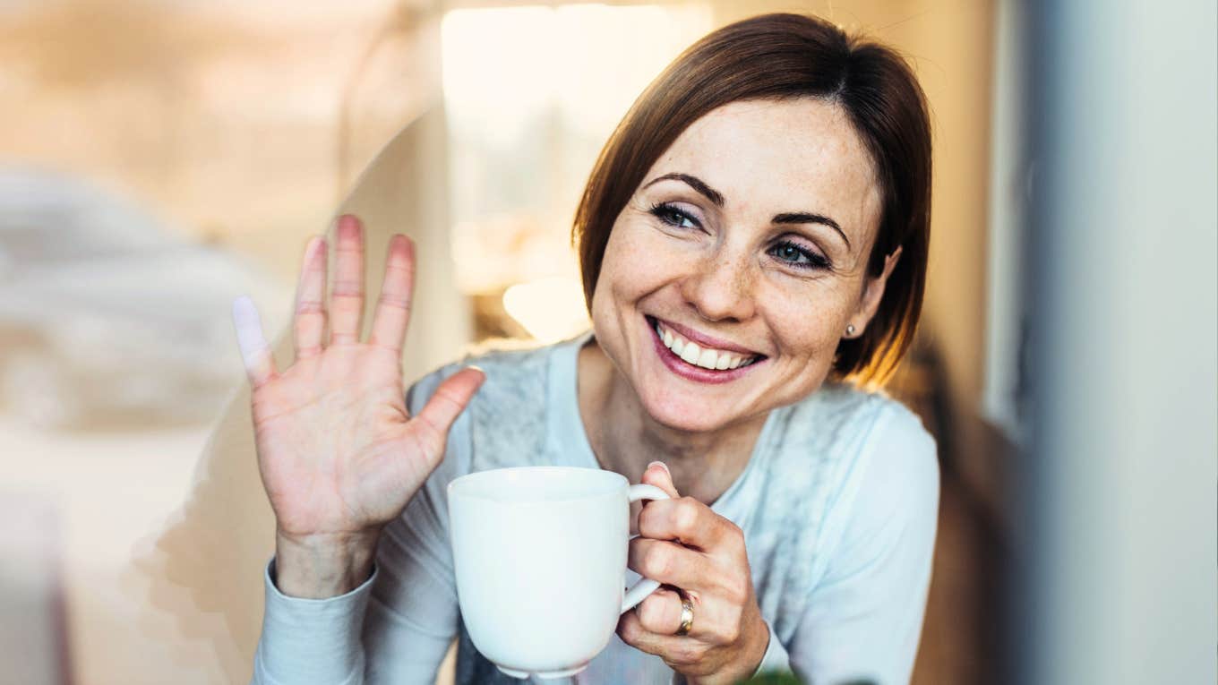 Warm, approachable person offering a small greeting wave, illustrating the natural habits that make someone effortlessly personable.