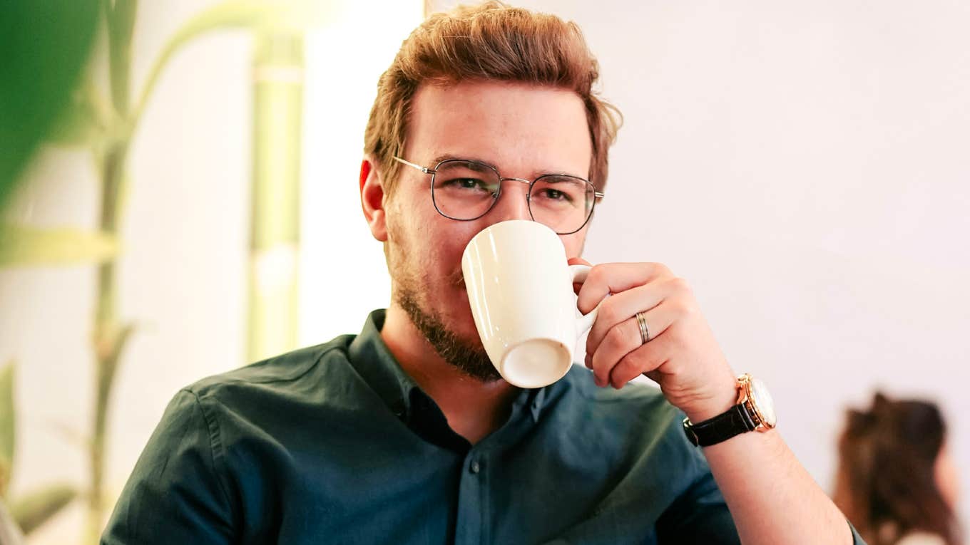 Confident, well-dressed man with a coffee cup and large watch, symbolizing the disciplined personalities that clash with procrastinators