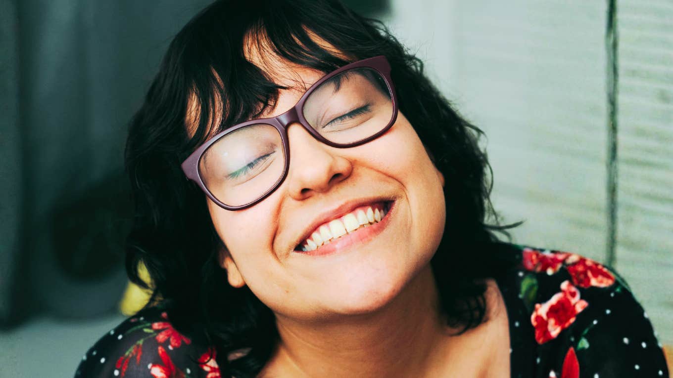 Blissfully happy woman representing independent living, self-love, and habits of single people who find joy and fulfillment on their own.