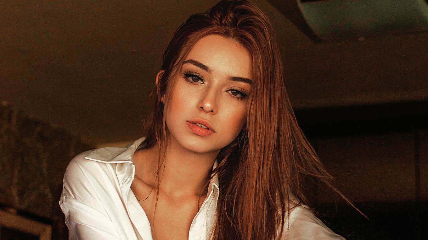 Seductive woman with long hair wearing a blouse, illustrating the simple habits and confidence of naturally seductive people.