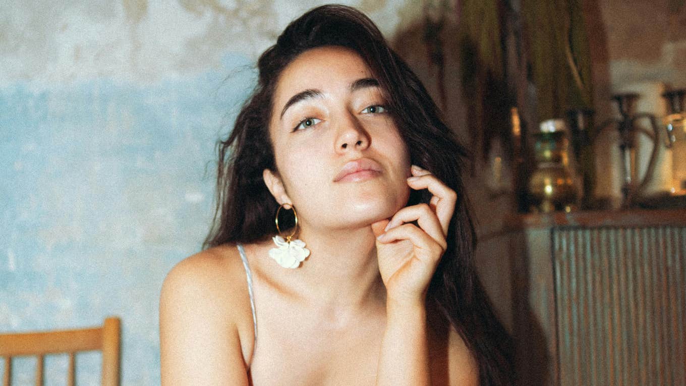 Confident woman raising an eyebrow subtly, showing quiet strength and grace while effortlessly shutting down condescending comments.