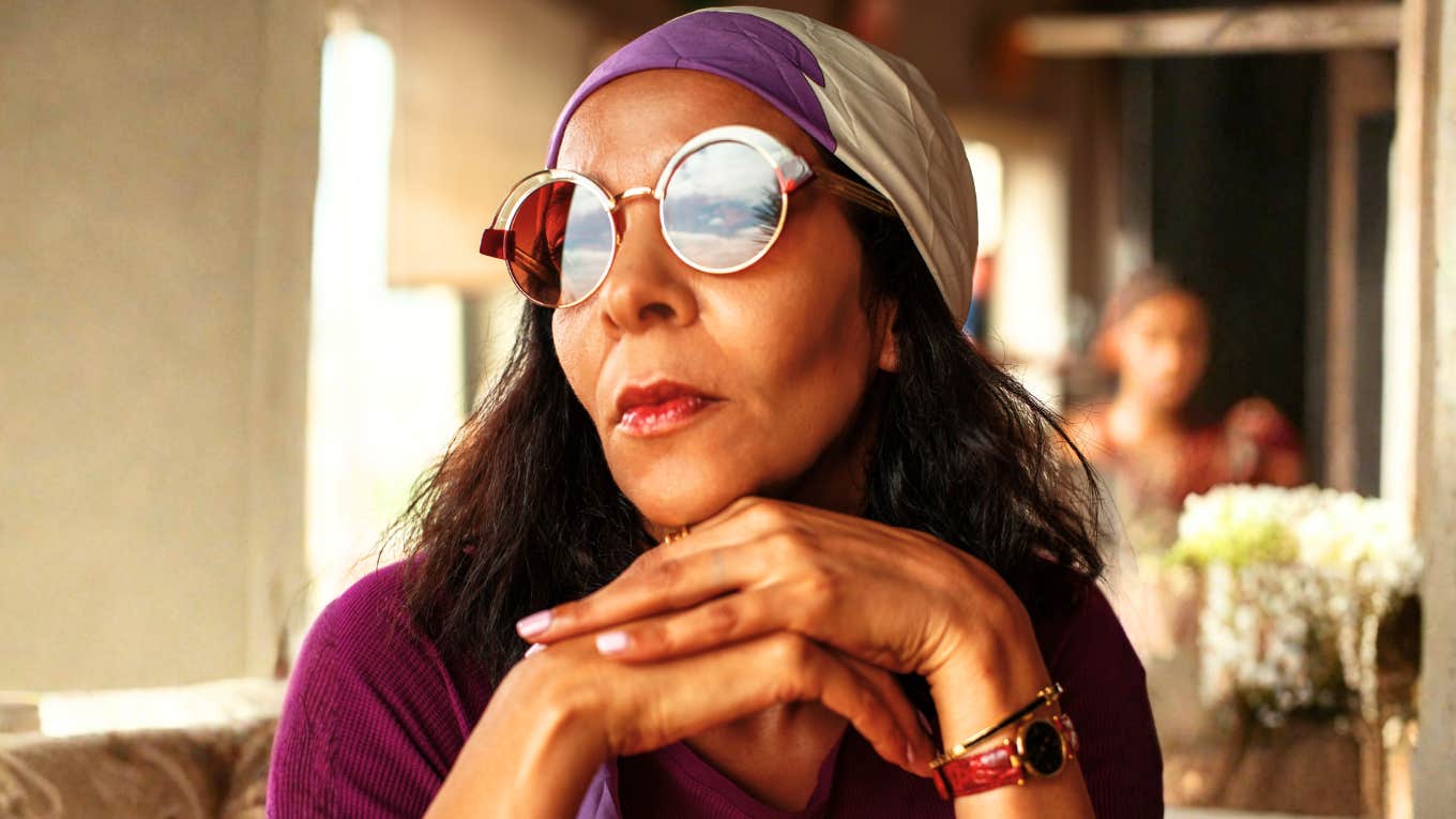 Calm, poised unbothered person seated outdoors in a strong stance, illustrating the unshakable confidence and daily habits of people who never doubt themselves