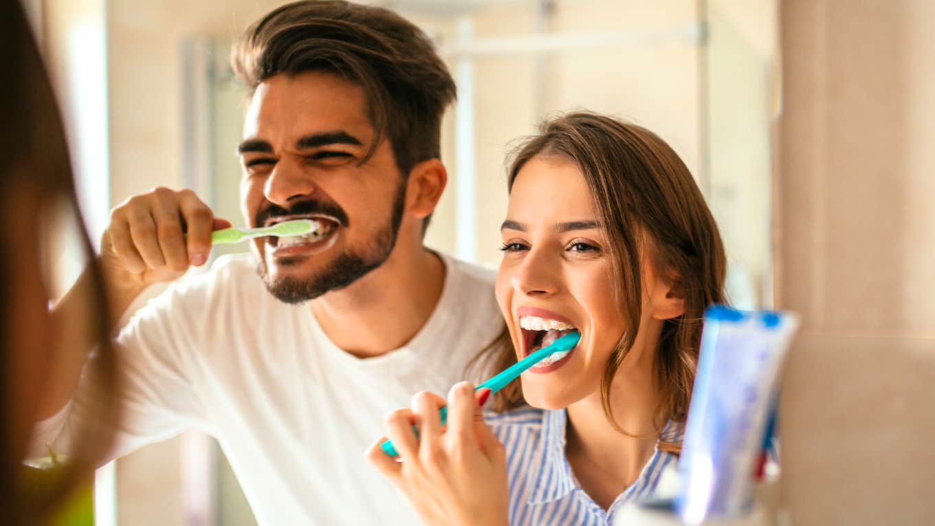 Couple brushing teeth together in the mirror, illustrating relatable everyday moments for people who’ve been in long-term relationships