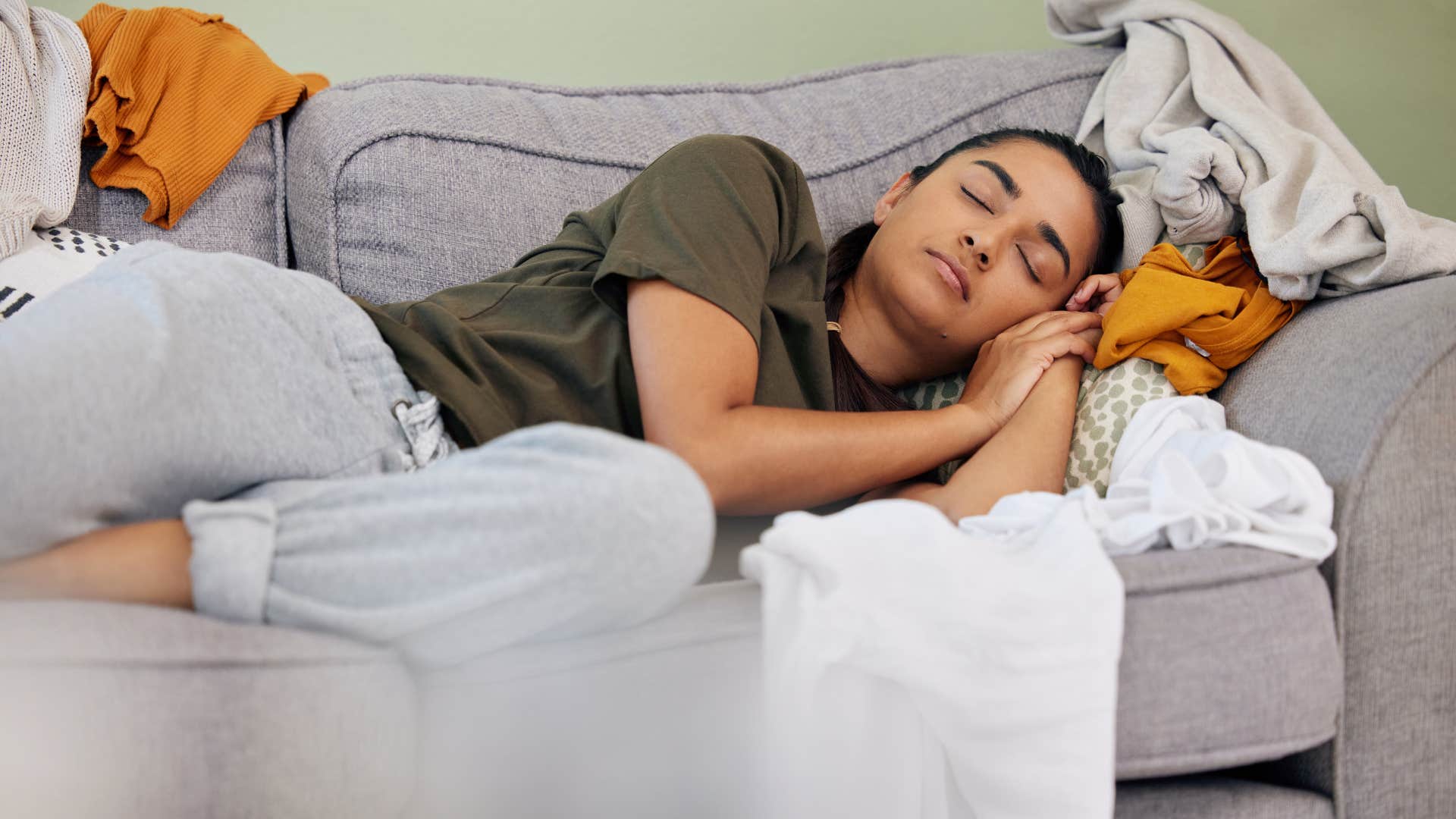 burnt out woman sleeping on messy couch