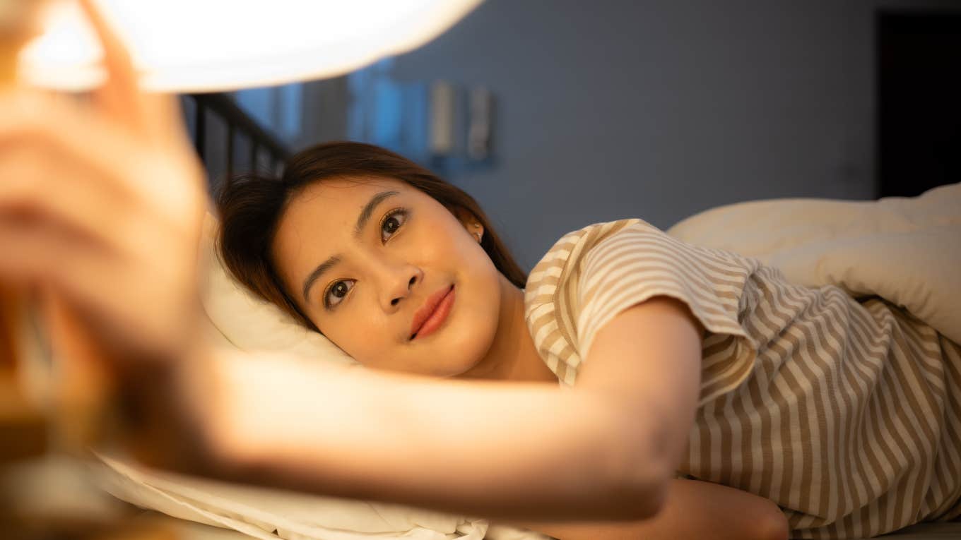 woman who loves herself turning the lights off at bedtime