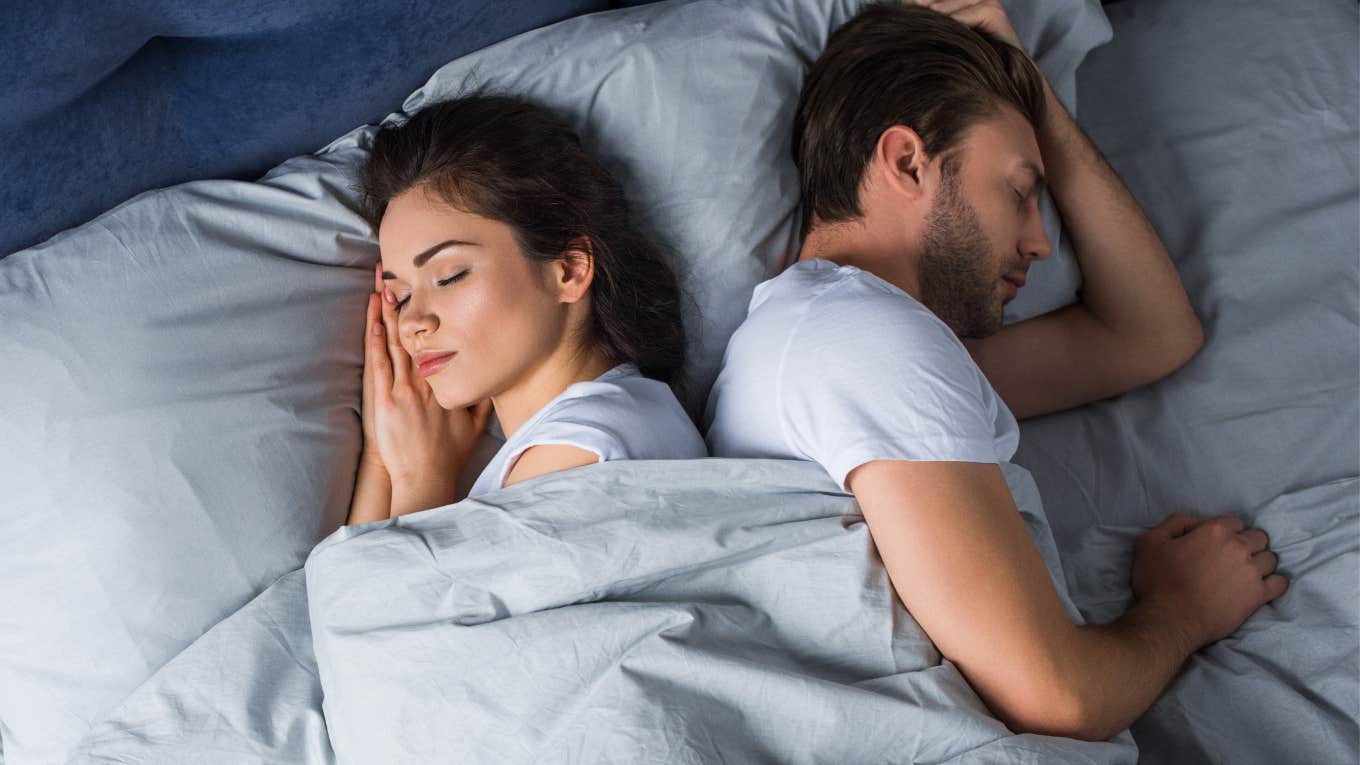 couple sleeping in bed facing away from each other