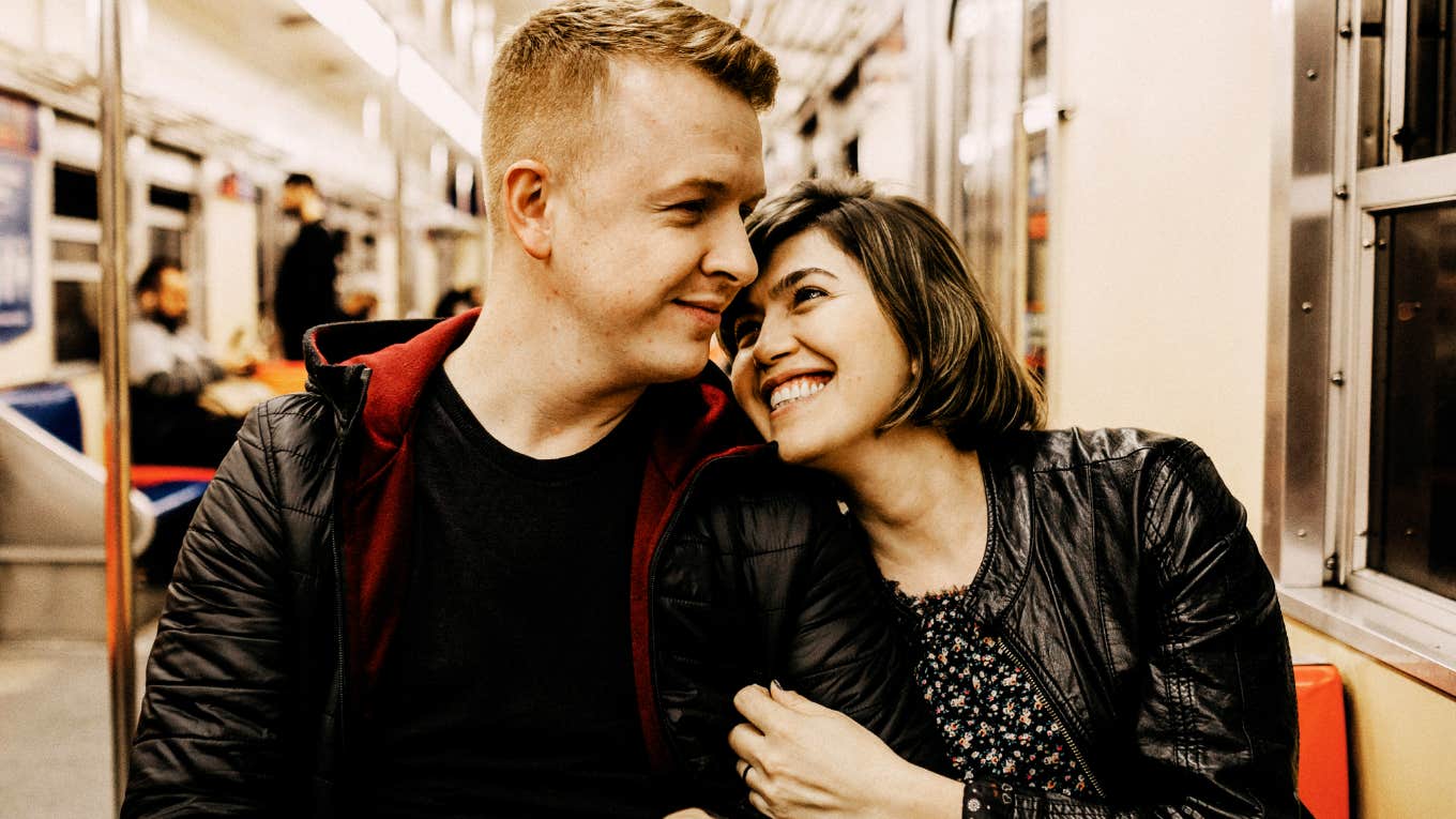 Man and woman sitting closely together on a train, illustrating habits that reveal whether two people are truly compatible, according to the CEO of eHarmony.