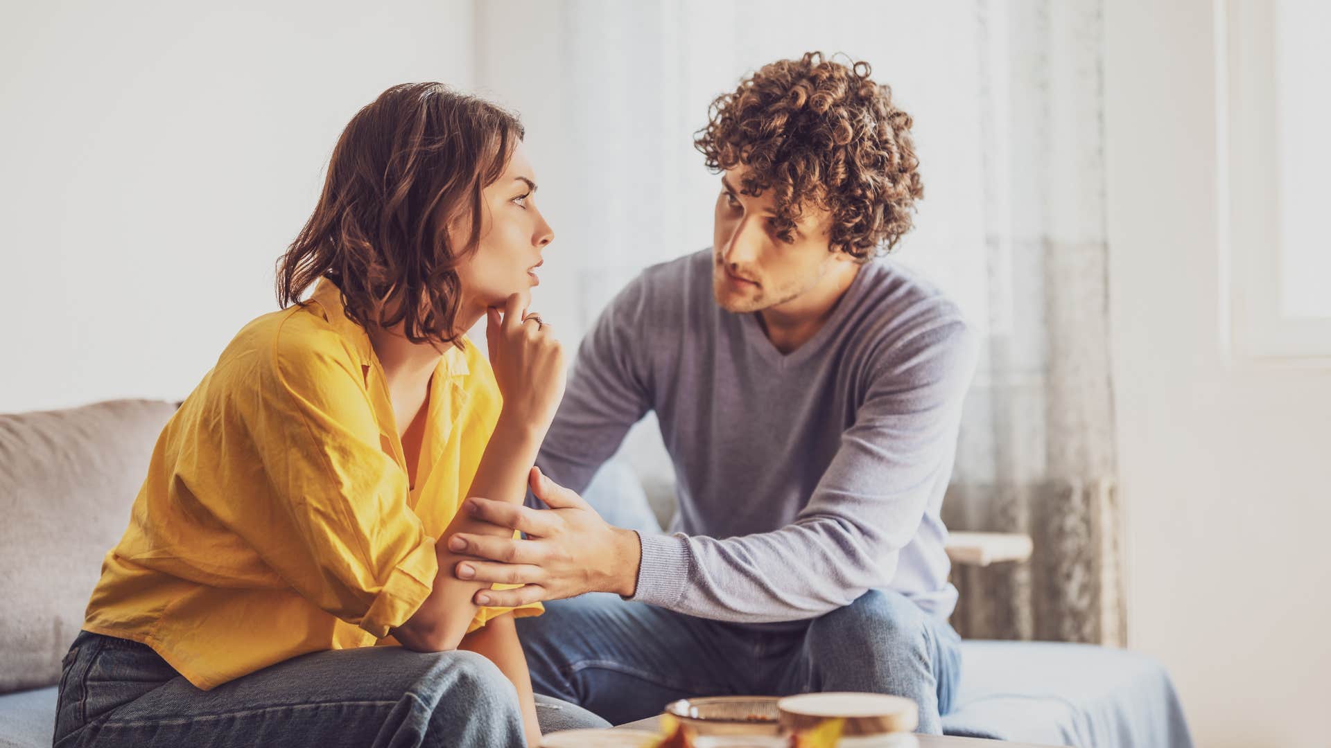 couple communicating honestly with each other as they sit on the couch and talk