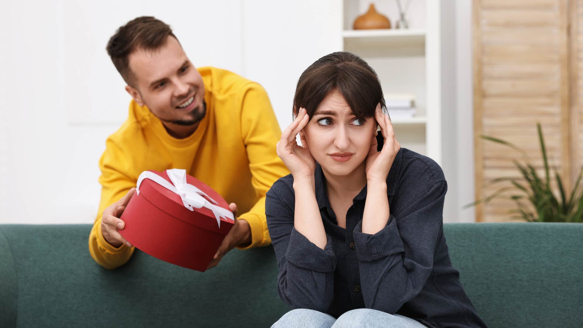woman who is in love with a man who is a narcissist as he gives her a gift that makes her scratch her head