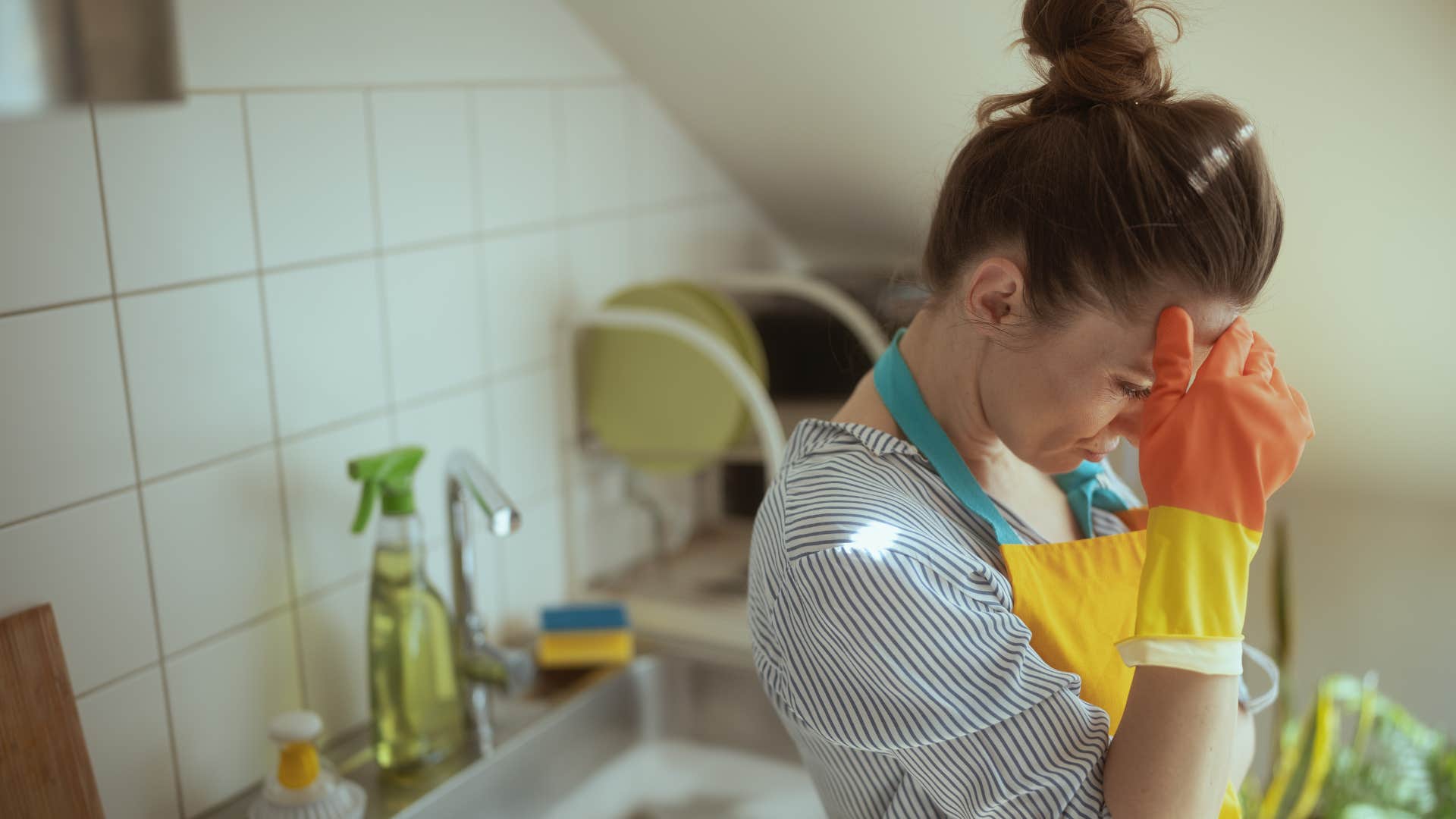 woman in apron looking stressed as she let the house get cluttered