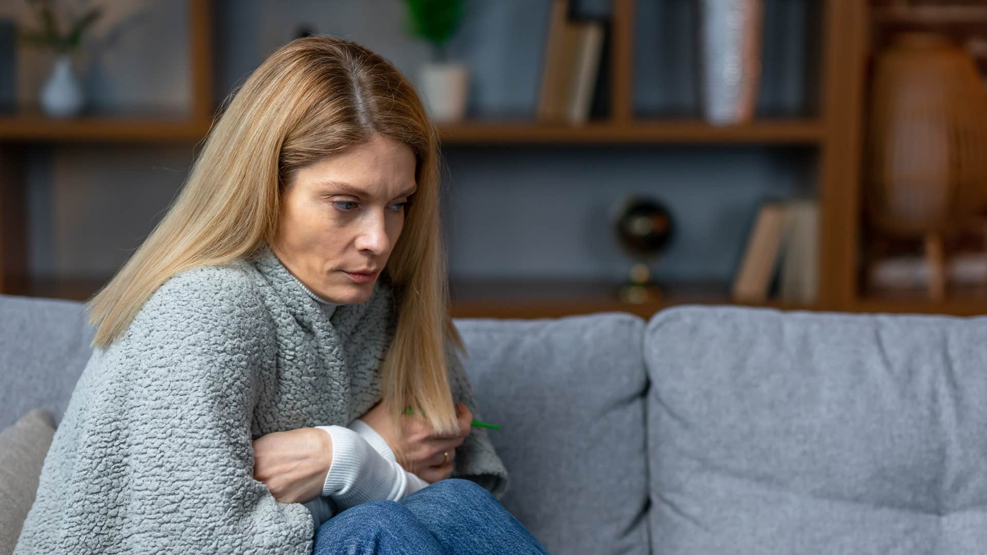 woman in gray sweater stops hosting or entertaining as she looks visibly depressed
