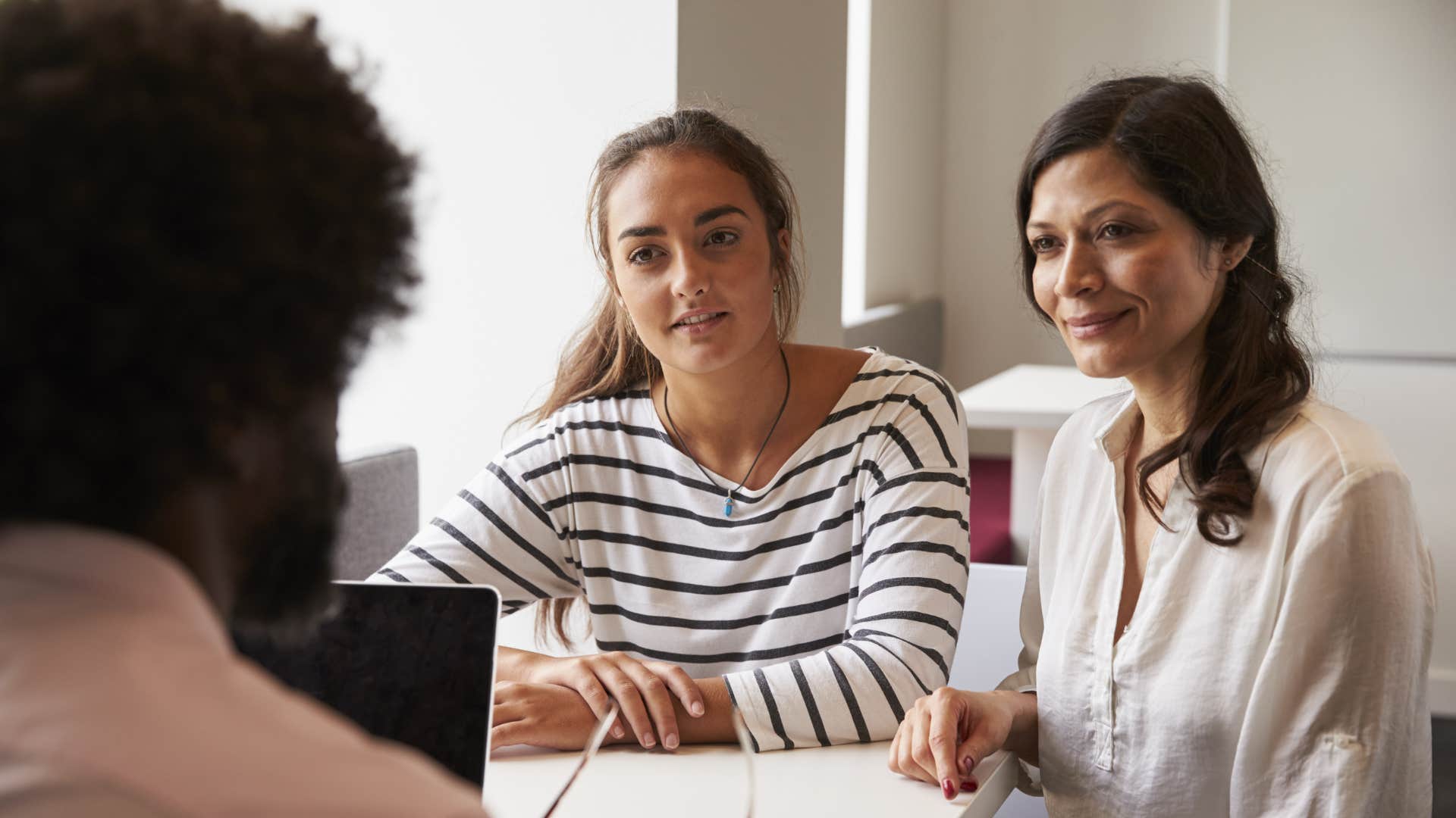 mom and teen daughter meeting with counselor about college