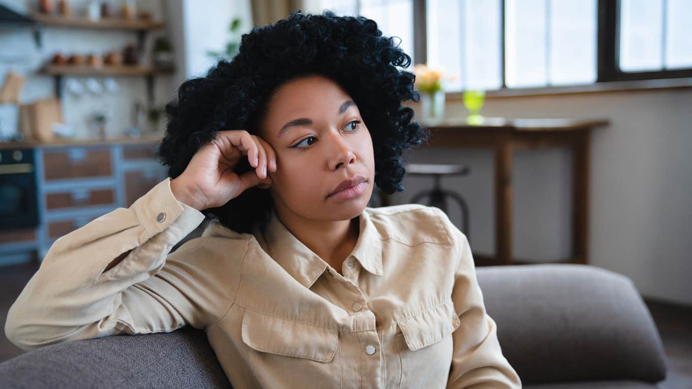 woman sitting on her couch feeling guilty for resting