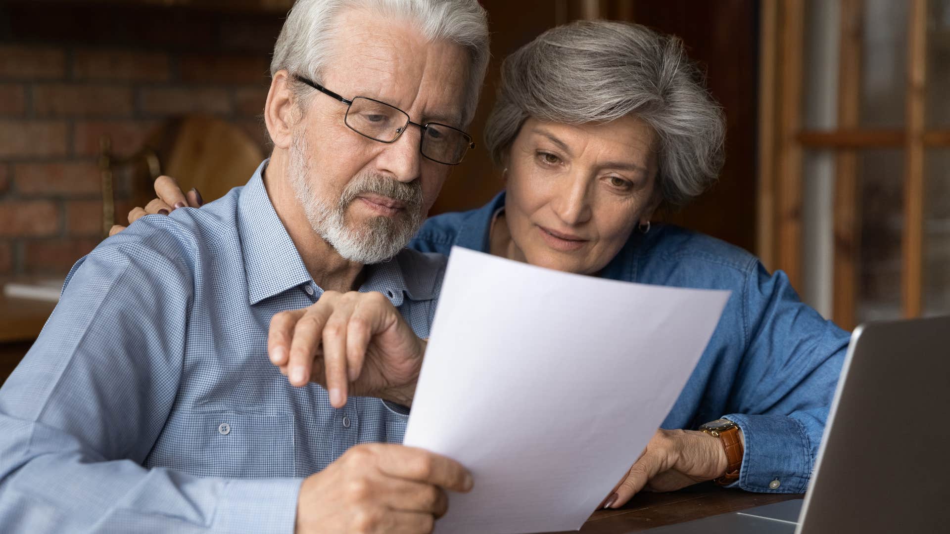 annoyed gen x couple looking at printed paper