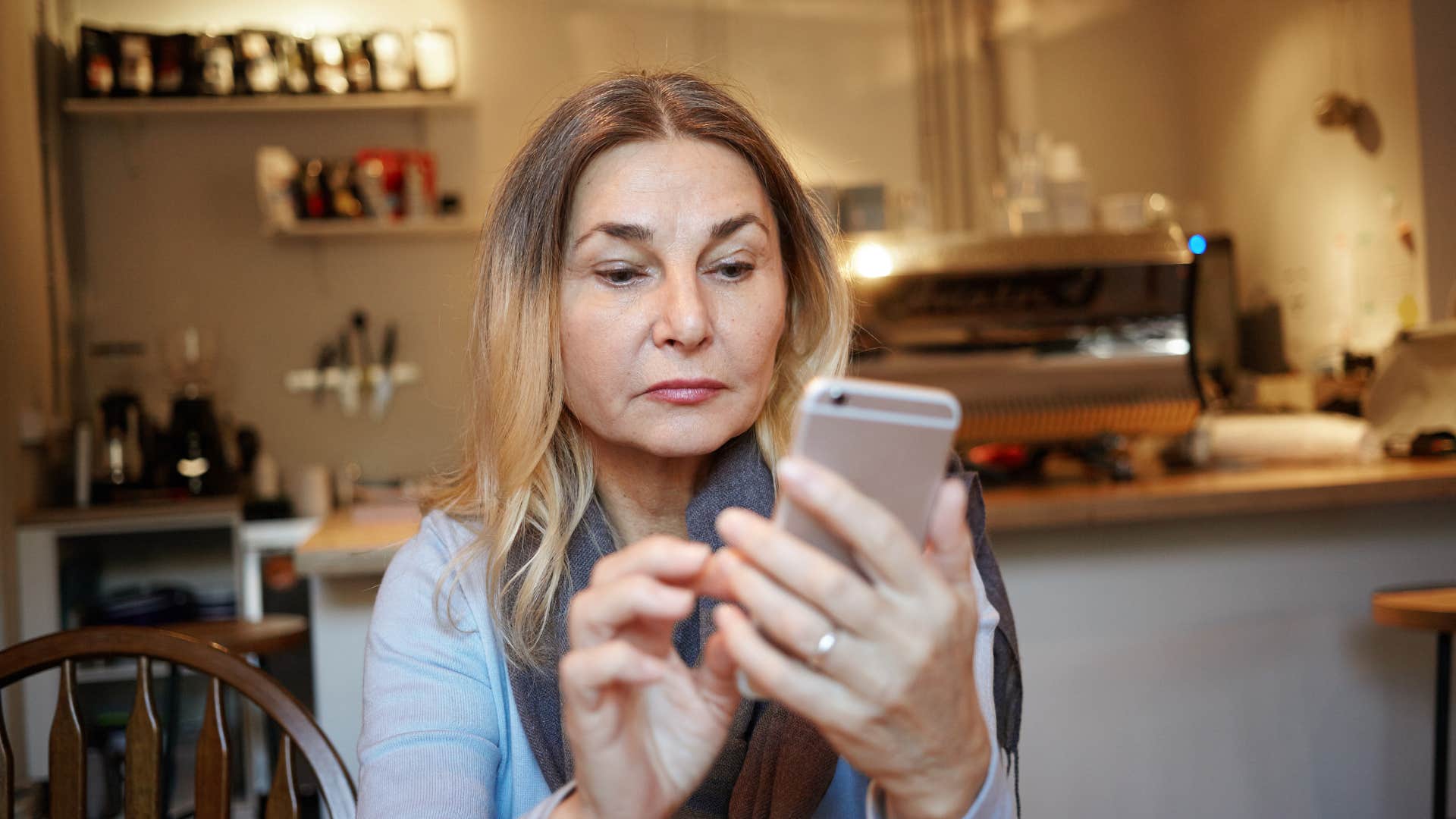 annoyed gen x woman looking at qr code on phone