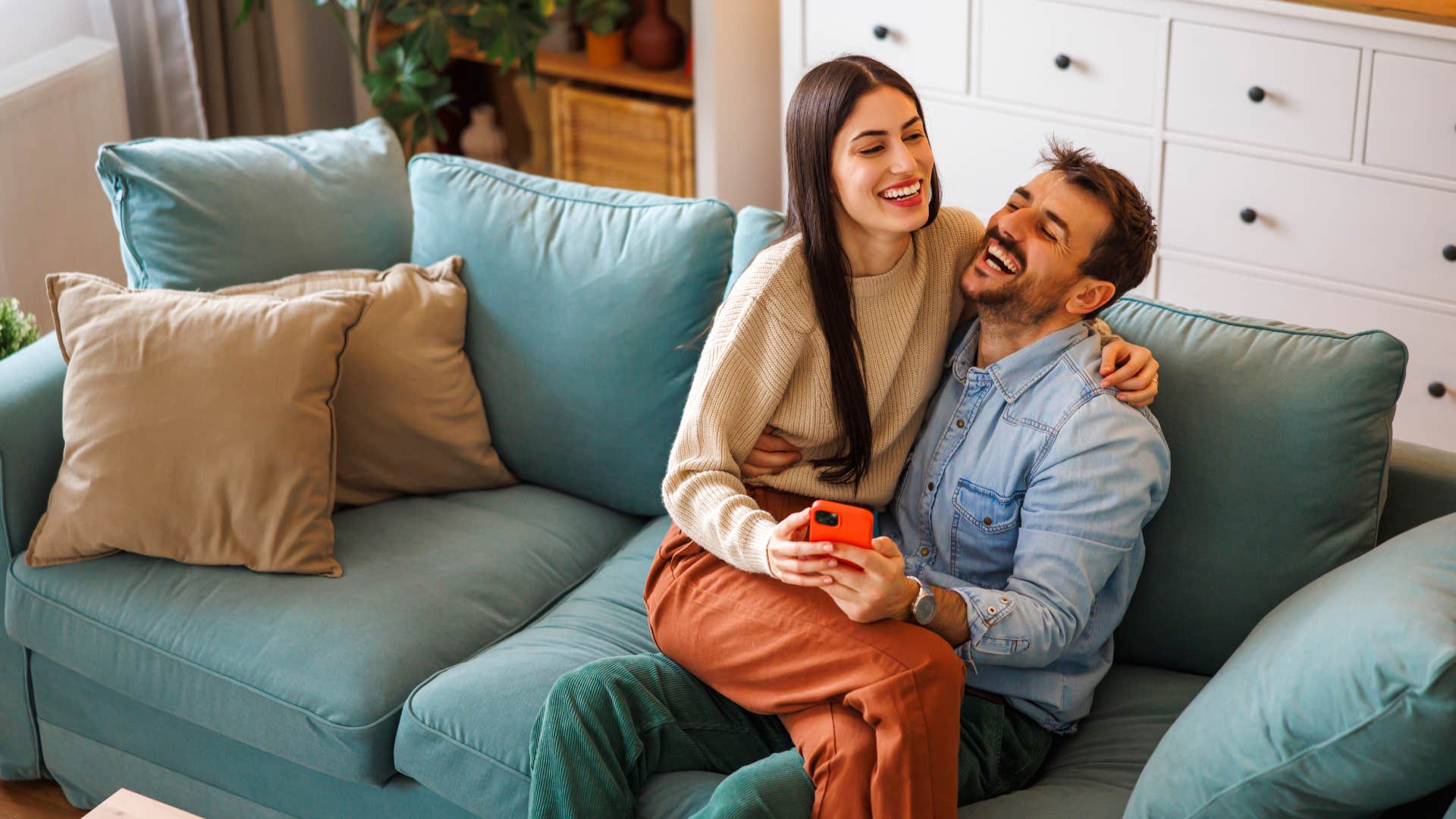 wife sitting on husband's lap smiling couple