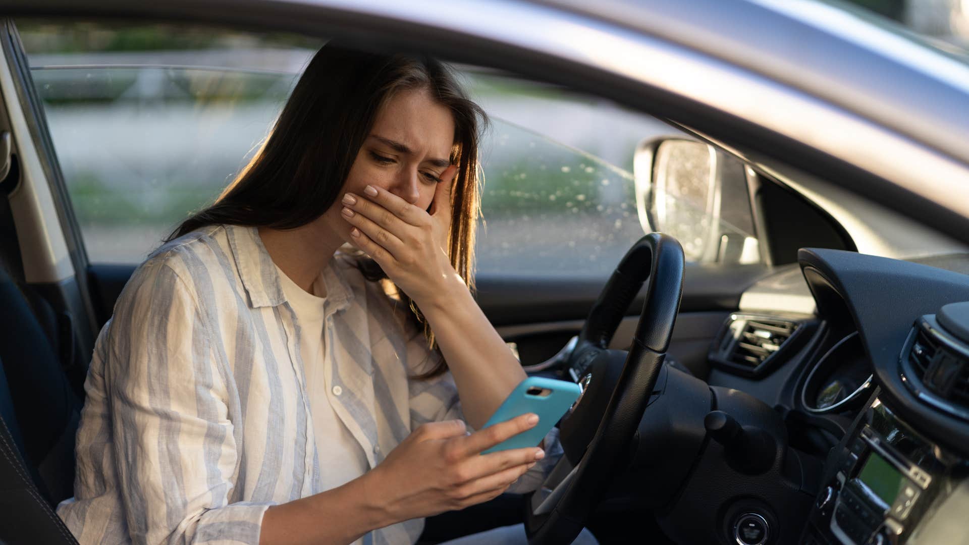 woman checking her bank account in the car